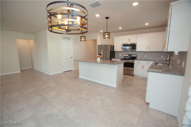 kitchen featuring a center island, white cabinets, stainless steel appliances, and sink