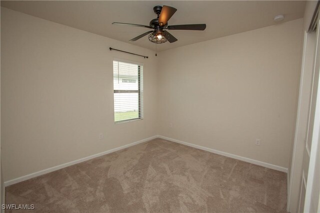 spare room with ceiling fan and light colored carpet