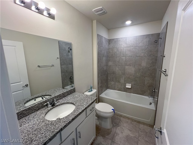 full bathroom with tile patterned floors, vanity, tiled shower / bath combo, and toilet