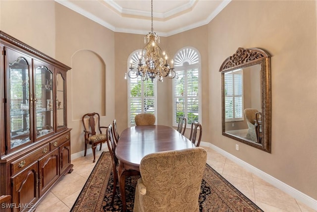 dining area featuring light tile patterned floors, a high ceiling, a tray ceiling, a chandelier, and crown molding