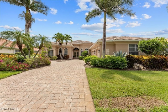 mediterranean / spanish-style house featuring a front lawn and a garage