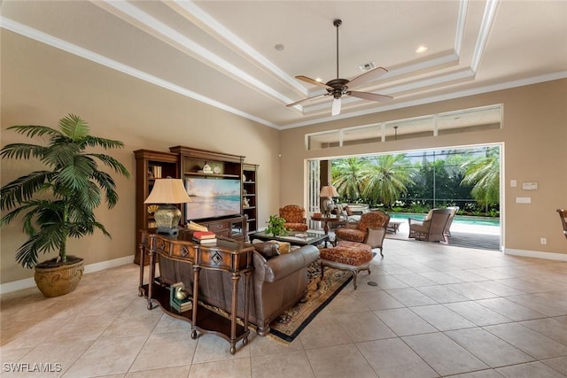 living room with ceiling fan, light tile patterned floors, crown molding, and a tray ceiling