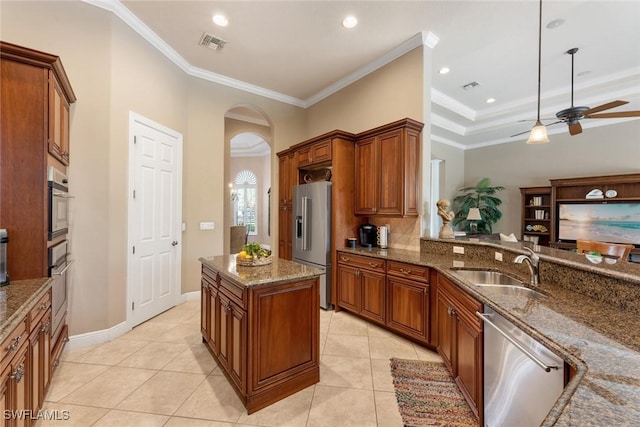 kitchen with light tile patterned floors, sink, appliances with stainless steel finishes, and dark stone countertops