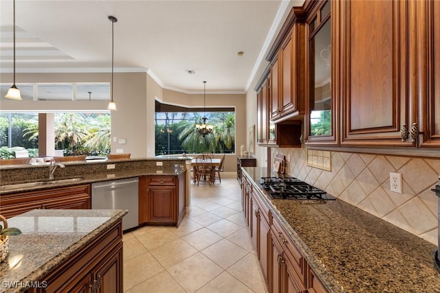 kitchen featuring appliances with stainless steel finishes, pendant lighting, dark stone counters, and sink