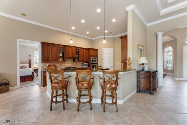 kitchen with kitchen peninsula, stainless steel oven, decorative columns, light tile patterned floors, and crown molding