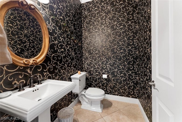 bathroom with sink, toilet, and tile patterned flooring