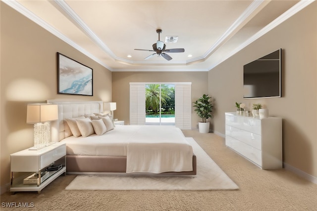 carpeted bedroom with ceiling fan, a tray ceiling, and crown molding