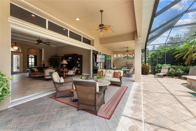 view of patio / terrace with ceiling fan, an outdoor hangout area, and glass enclosure