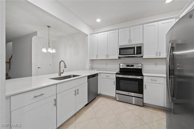 kitchen with sink, white cabinets, hanging light fixtures, and appliances with stainless steel finishes