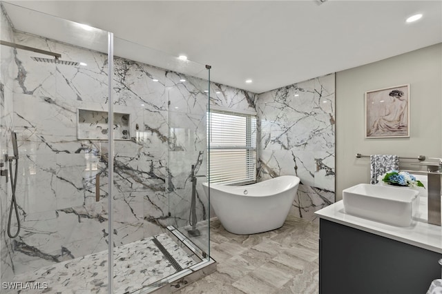 bathroom with tile walls, vanity, and shower with separate bathtub