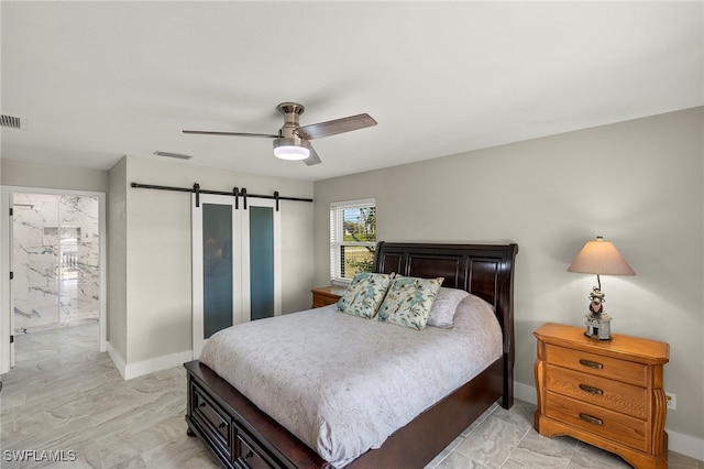 bedroom with ceiling fan, a barn door, and connected bathroom