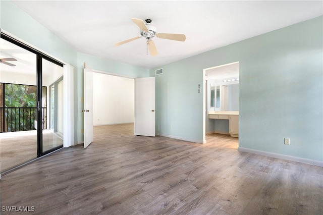 unfurnished bedroom featuring hardwood / wood-style floors, ceiling fan, access to outside, and ensuite bath