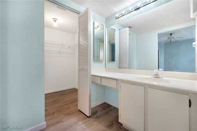 bathroom with hardwood / wood-style flooring, ceiling fan, and vanity