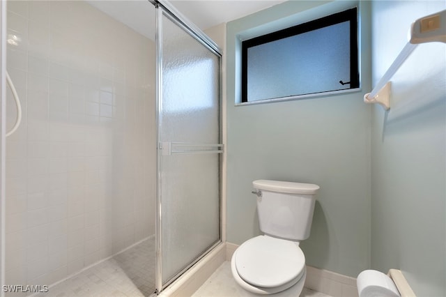 bathroom with a shower with shower door and toilet