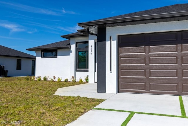 view of exterior entry with a garage and a yard