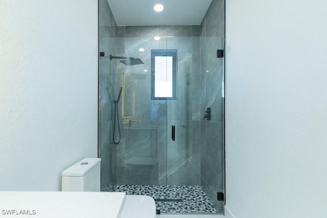 bathroom featuring toilet and an enclosed shower