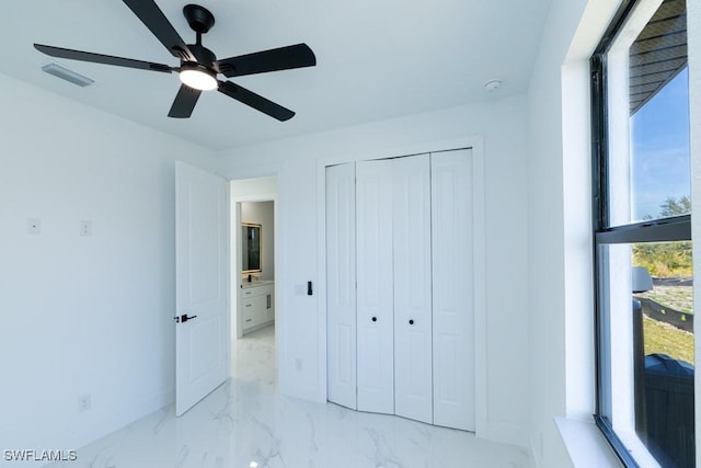 unfurnished bedroom with ceiling fan and a closet