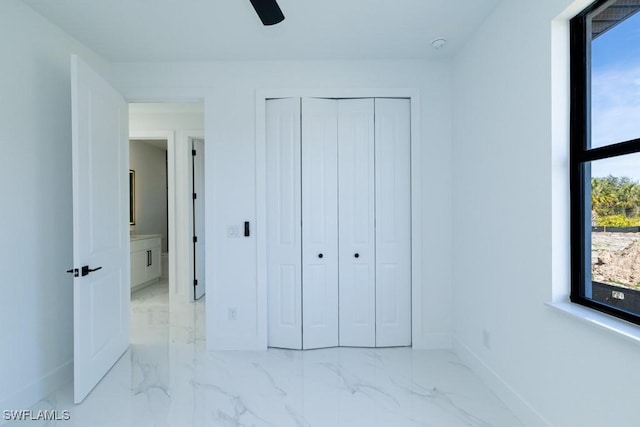 unfurnished bedroom with ceiling fan and a closet