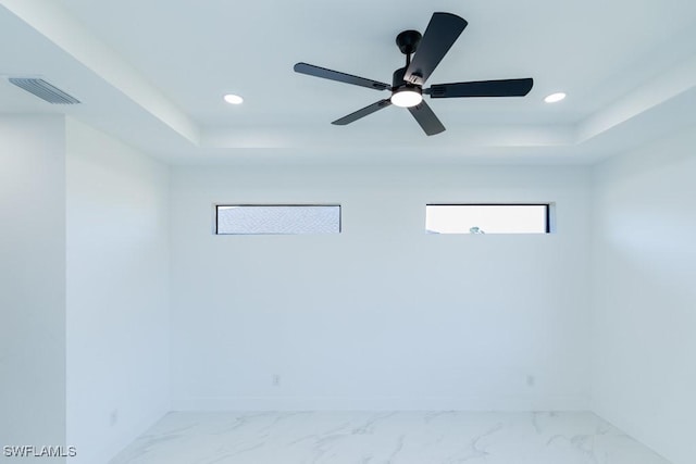 unfurnished room with a raised ceiling and ceiling fan