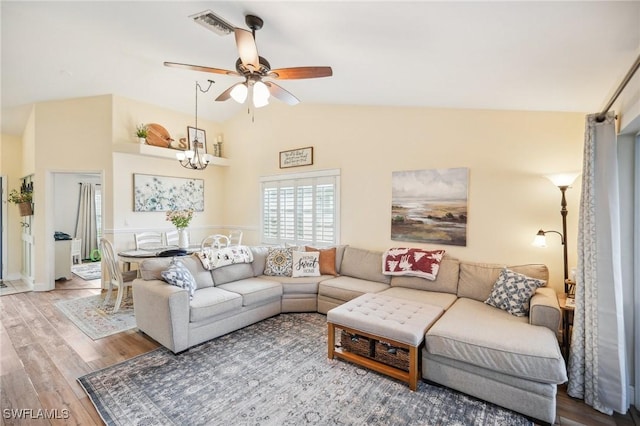 living room featuring ceiling fan with notable chandelier, lofted ceiling, and hardwood / wood-style floors