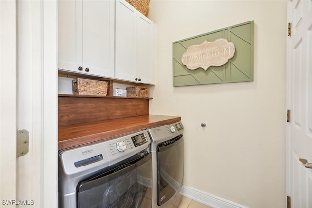 clothes washing area with cabinets and separate washer and dryer