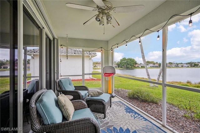 sunroom / solarium featuring ceiling fan and a water view