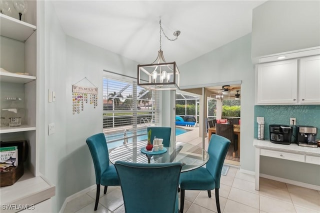 tiled dining room featuring an inviting chandelier, lofted ceiling, and plenty of natural light