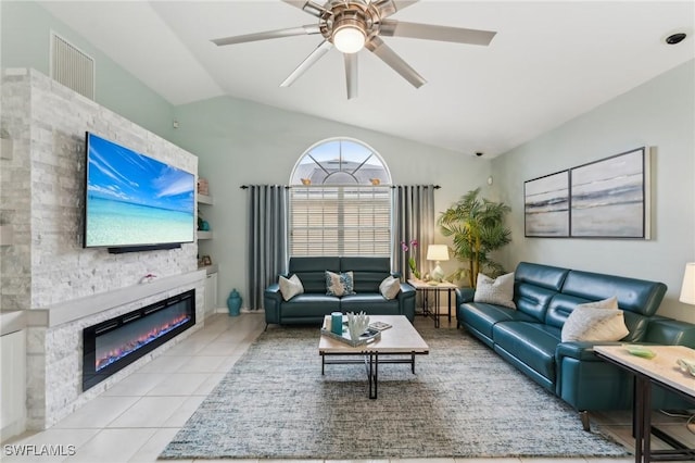 tiled living room featuring a fireplace, ceiling fan, and vaulted ceiling