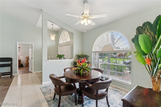 dining room with plenty of natural light, a towering ceiling, light tile patterned floors, and ceiling fan