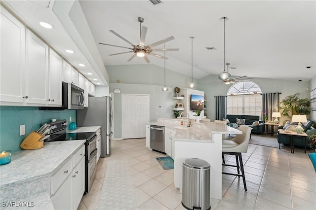 kitchen with sink, white cabinets, hanging light fixtures, ceiling fan, and stainless steel appliances