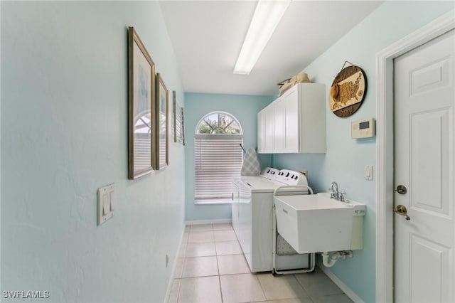 clothes washing area featuring cabinets, separate washer and dryer, sink, and light tile patterned floors