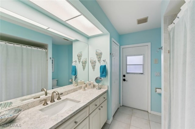 bathroom with vanity, tile patterned floors, and toilet