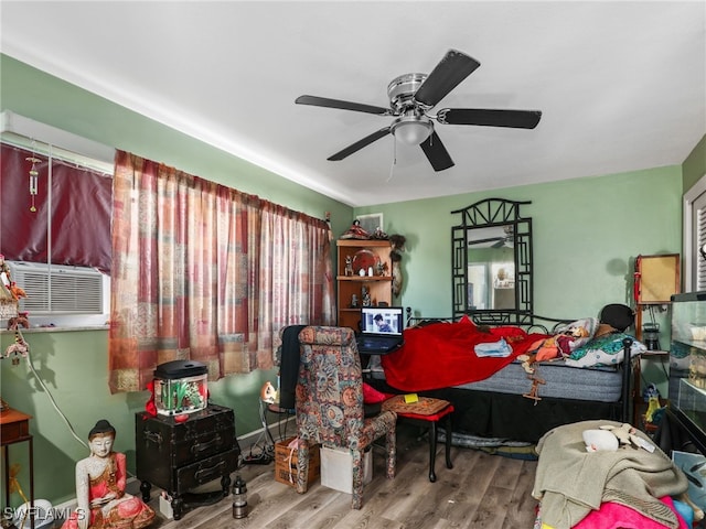 bedroom with ceiling fan, wood-type flooring, and cooling unit