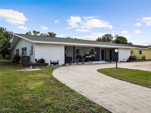 rear view of house featuring covered porch and a yard