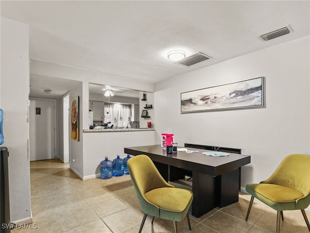 tiled dining space with a textured ceiling