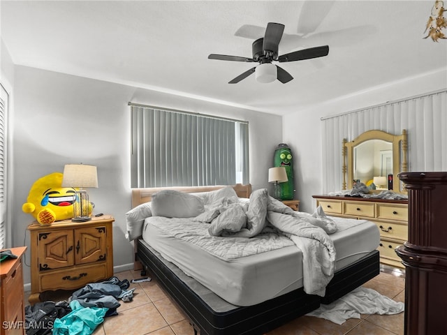 tiled bedroom featuring ceiling fan