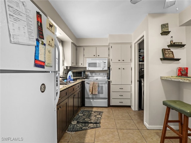 kitchen with sink, white appliances, and light tile patterned floors