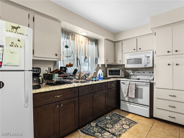 kitchen with white cabinetry, white appliances, light tile patterned flooring, dark brown cabinetry, and sink