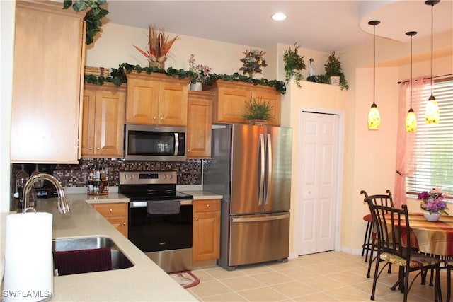 kitchen with sink, stainless steel appliances, tasteful backsplash, decorative light fixtures, and light tile patterned flooring