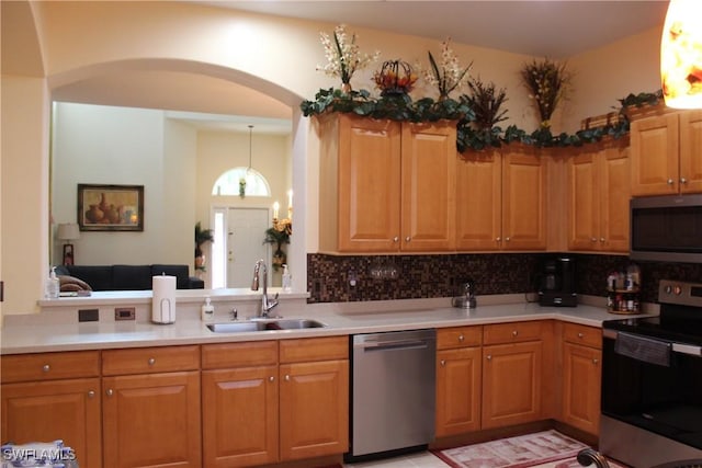 kitchen featuring backsplash, sink, hanging light fixtures, and appliances with stainless steel finishes