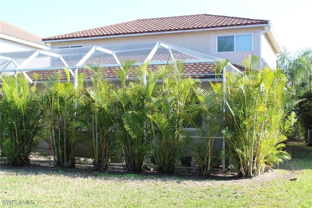 view of side of property featuring glass enclosure