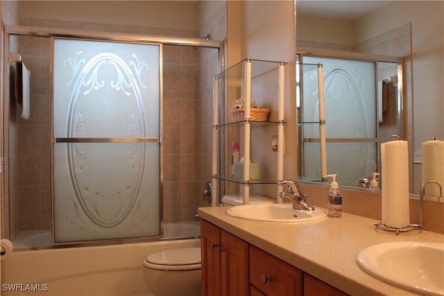 full bathroom featuring vanity, toilet, and shower / bath combination with glass door