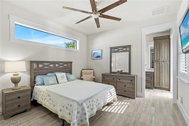 bedroom with ceiling fan, connected bathroom, and light hardwood / wood-style flooring