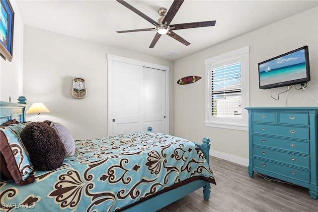 bedroom with wood-type flooring, a closet, and ceiling fan