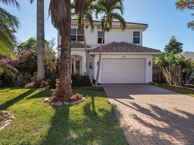 mediterranean / spanish-style home featuring a front yard and a garage