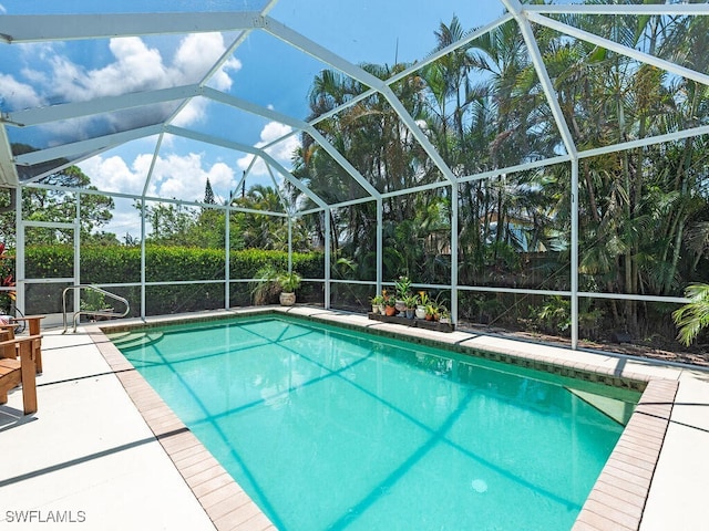 view of swimming pool featuring glass enclosure and a patio area