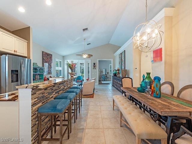 kitchen featuring stainless steel fridge, decorative light fixtures, lofted ceiling, light tile patterned flooring, and ceiling fan with notable chandelier