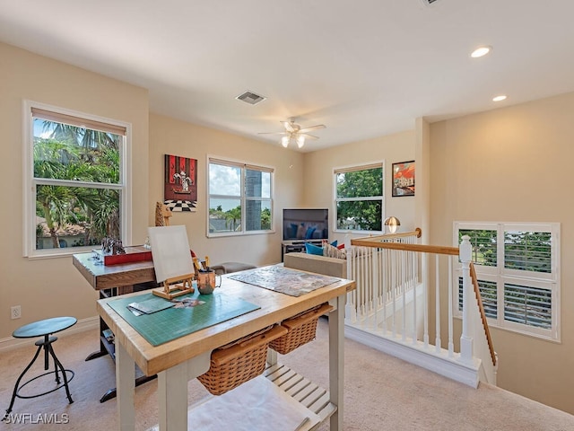 carpeted office with ceiling fan and plenty of natural light