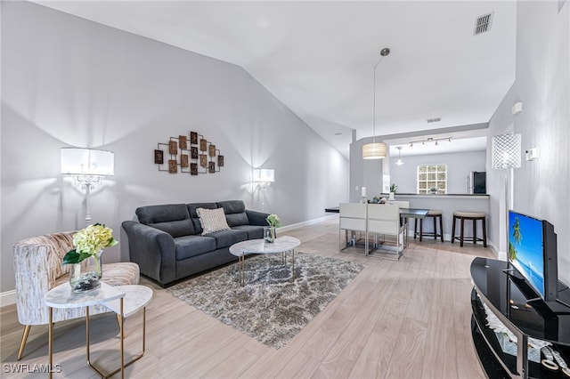 living room featuring vaulted ceiling and light hardwood / wood-style flooring