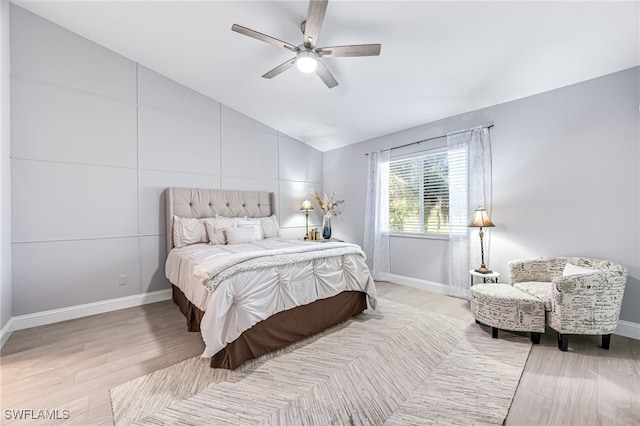 bedroom with ceiling fan, lofted ceiling, and light hardwood / wood-style flooring